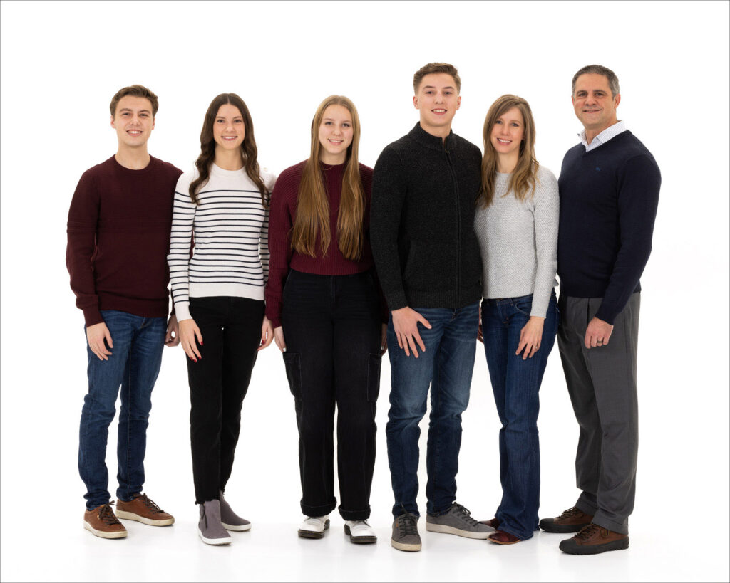 A Family standing united, exuding joy in front of a plain white background.